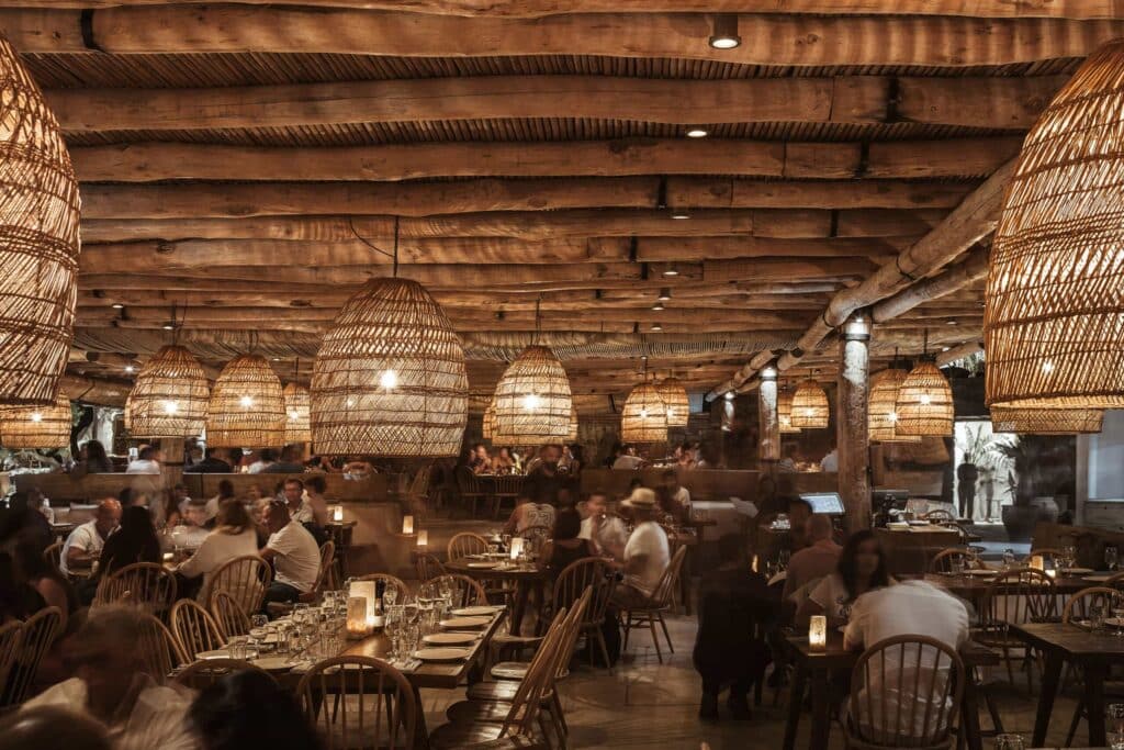 Restaurant dining area with woven pendant lights at Scorpios Mykonos